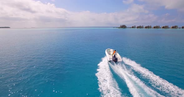 Aerial drone view of a man water skiing near a tropical island.