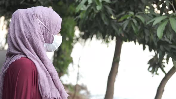 Thoughtful Muslim Woman with Flu Mask Looking Away