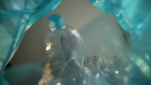 View From the Trash Can a Man in a Protective Suit Takes Plastic Bottles To a Separate Collection of