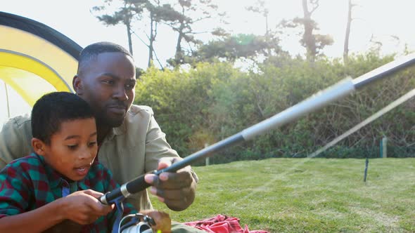 Father teaching son how to catch a fish