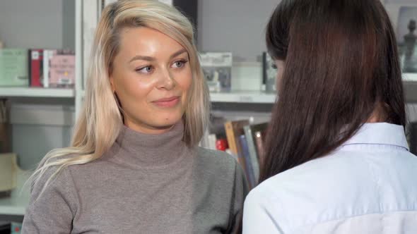 Beautiful Woman Smiling, Talking To Her Friend at the Bookstore or Library