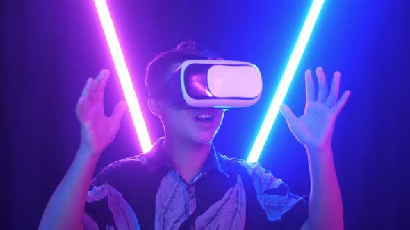 Vr, Futuristic, Excited Asian Boy Using Virtual Reality Headset With Neon Light At The Background