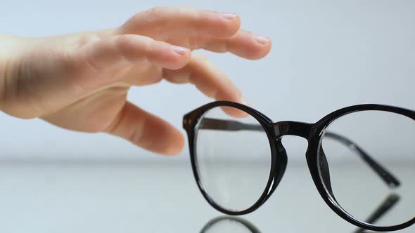 Child Hands Taking Eyeglasses From Table