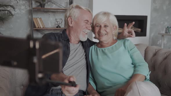 Excited Mature Couple Having Fun with Phone Together, Posing for Photo, Taking Selfie, Smiling Older