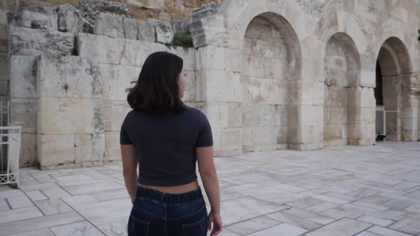 Slowmotion shot of a young woman who walks an turns around and smiles.