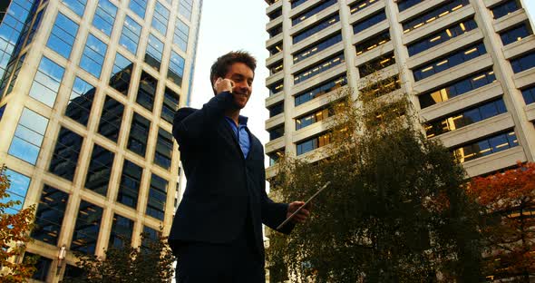 Businessman talking on mobile phone and holding digital tablet