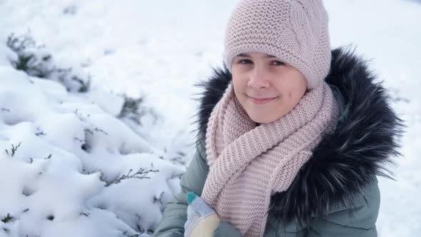 Teen by the snowy tree.