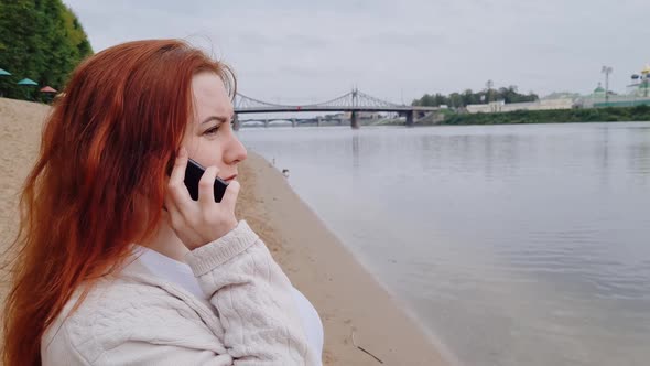Young Redhaired Woman Talking on Phone and Laughing