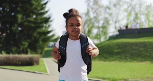 Schoolgirl with a Backpack Runs Home in the Park From Her School Dream on a Sunny Day