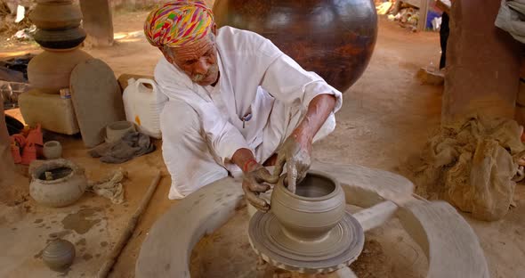 Skilled Professional Potter Throwing the Potter's Wheel and Shaping Traditional Ceramic Vessel