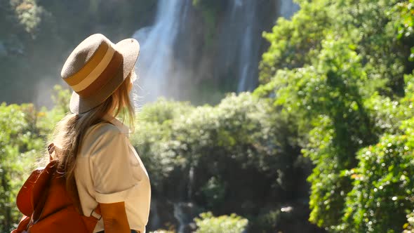 Travel Woman Enjoy Amazing View of Waterfall Nature