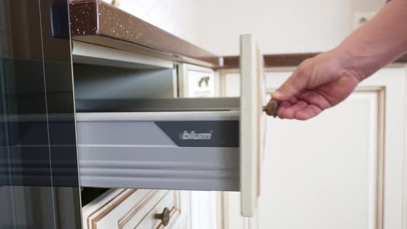 A Man's Hand Opens and Closes the Kitchen Drawer with BLUM Fittings