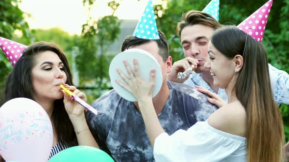 Friends Throw Birthday Cake at Mans Face, He Smiles and Laughs, Joke on Party