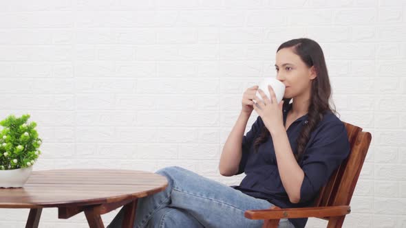 Indian girl enjoying coffee at a cafe bar