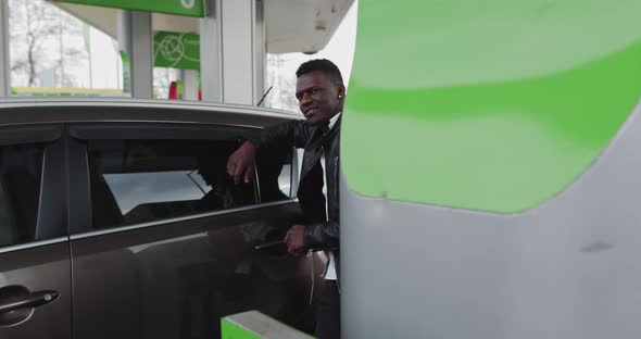 Portrait Of An African Guy At A Gas Station With Coffee In Hands