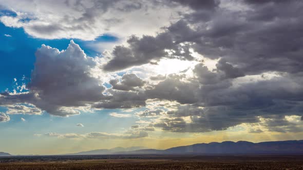 Aerial Hyperlapse of dark storm clouds engulfing brightly shining sun in desert