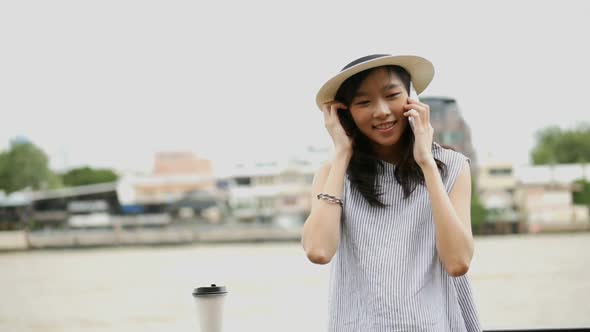 Young Asian woman talking on a cellphone.