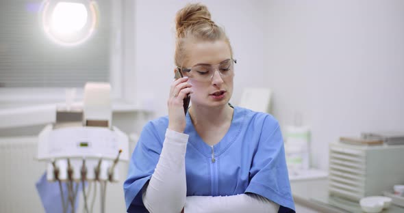 Female Doctor Talking on Mobile Phone at Healthcare Clinic