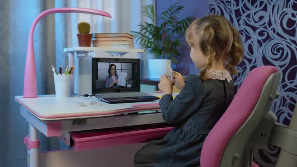 Child Girl Looking at Web Camera Making Video Call Learning Geometric Shapes with Teacher at Home