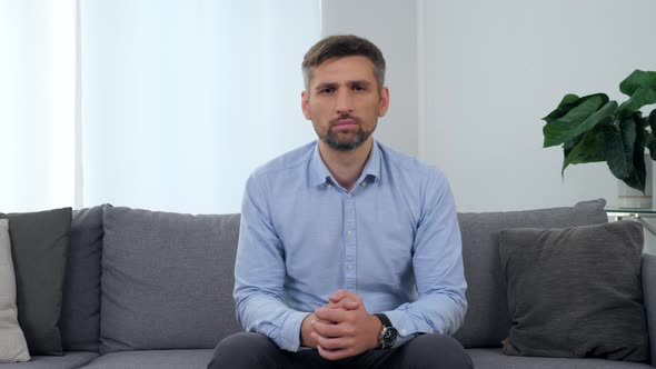 Portrait Adult Man Patient Sitting on Couch in Clinic Office Looking Camera