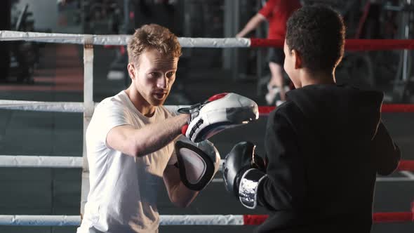 Boy Boxer Practicing Punches with His Coach at Gym
