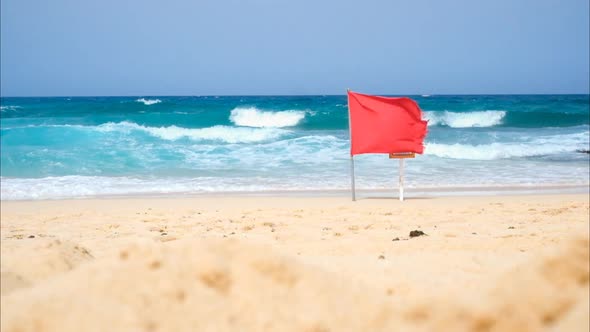 Summer beach with red flag warning - `prohibition to swim - yellow sandy beach