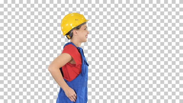 Young woman in yellow hardhat walking, Alpha Channel