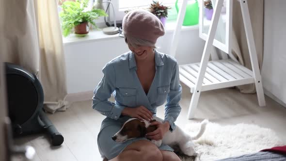 Young blonde girl with dog at home interior