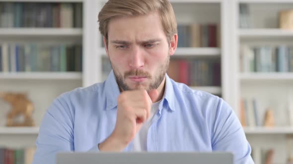 Portrait of Man Coughing While Using Laptop