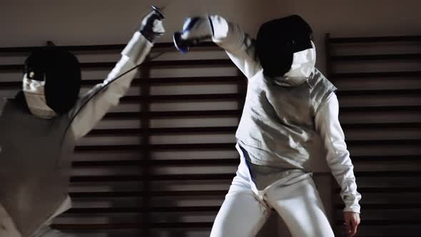 Men in Fencing Masks Thrusting with Foils in Duel