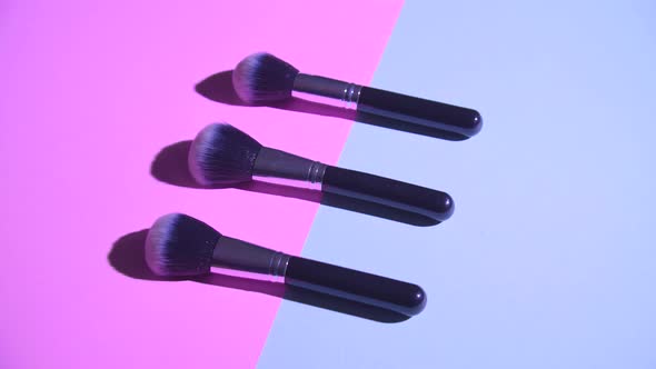 Set of Flat Top View of Professional Female Cosmetics Brush for Makeup on Pink and Blue Background