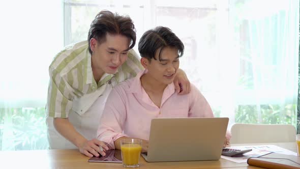 Asian gay couple takes care of boyfriend, surfing on internet during break, give each other hi five