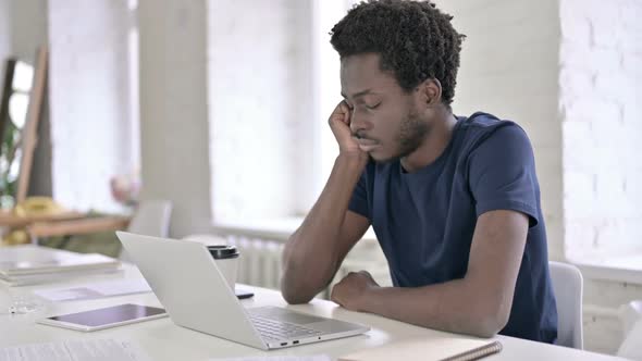 Young African Man Having Quick Nap on Office Desk