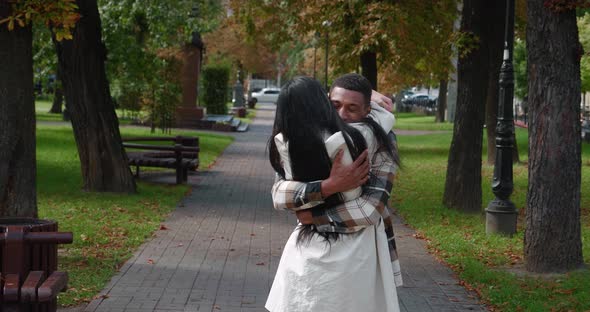 Young Cheerful African Man and Pretty Woman Walking Towards Each Other Rejoicing at the Meeting