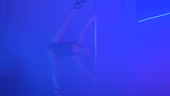 Young Sexy Slim Woman Pole Dancing with Pylon in Dark Interior