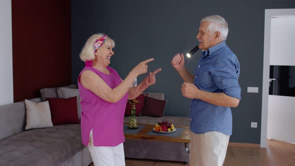 Senior Couple Dancing Laughing at Home. Grandparents Relaxing Having Fun Celebrating Anniversary