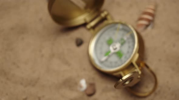 Gold Compass on Sand Background Closeup Focusing of Golden Compass