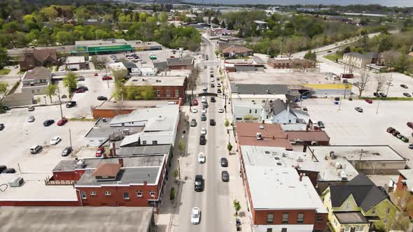 Aerial descend flyover downtown of Grimsby during many cars passing road in summer,Canada.