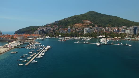 View From the Drone to the Piers Against the Background of Buildings and Mountains of Budva