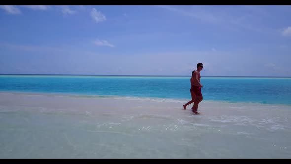 Romantic couple sunbathing on tranquil island beach journey by aqua blue sea and white sandy backgro