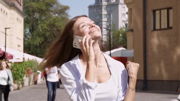 Happy and excited woman walking at the street.