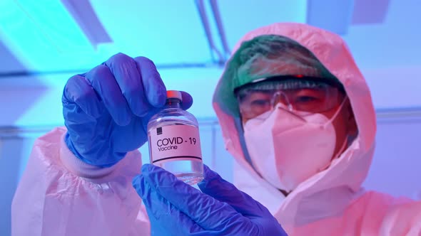 Scientist in PPE suit conducts research on the COVID 19 vaccine at a laboratory.