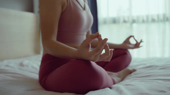 Close-up hand of woman in sportsware practice yoga lotus pose to meditation at home.