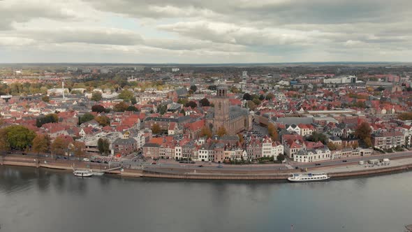 Aerial drone shot closing in on the Dutch medieval city of Deventer from the other side of the river