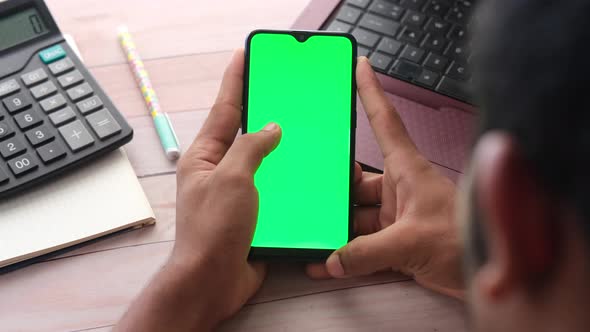 Rear View of Man Hand Using Smart Phone on Office Desk