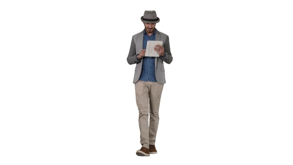 Handsome smiling arab man in a hat walking and using tablet