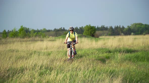 Woman Cyclist Moving On Bike On Countryside
