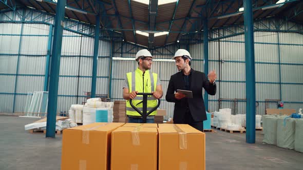 Factory Workers Deliver Boxes Package on a Pushing Trolley in the Warehouse