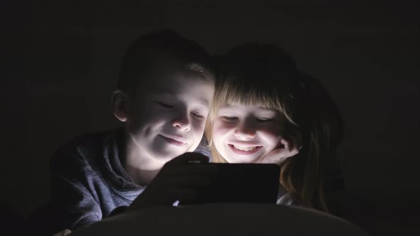 Two Children Brother and Sister Watching Video on Smartphone Screen Together