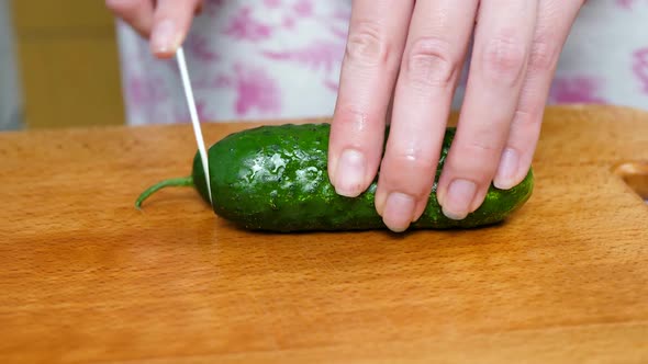 Cutting Fresh Green Cucumber on Wooden Board